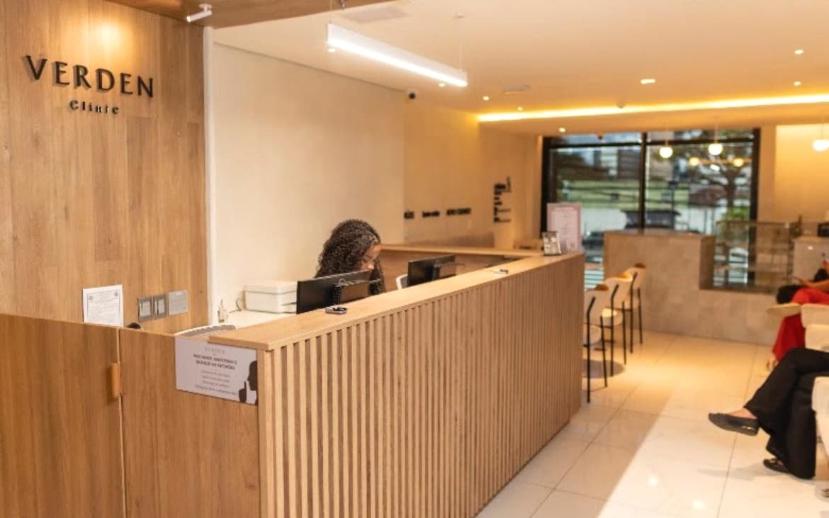 Recepção do consultório do Dr. Lucas Pimentel, com balcão de atendimento e iluminação aconchegante